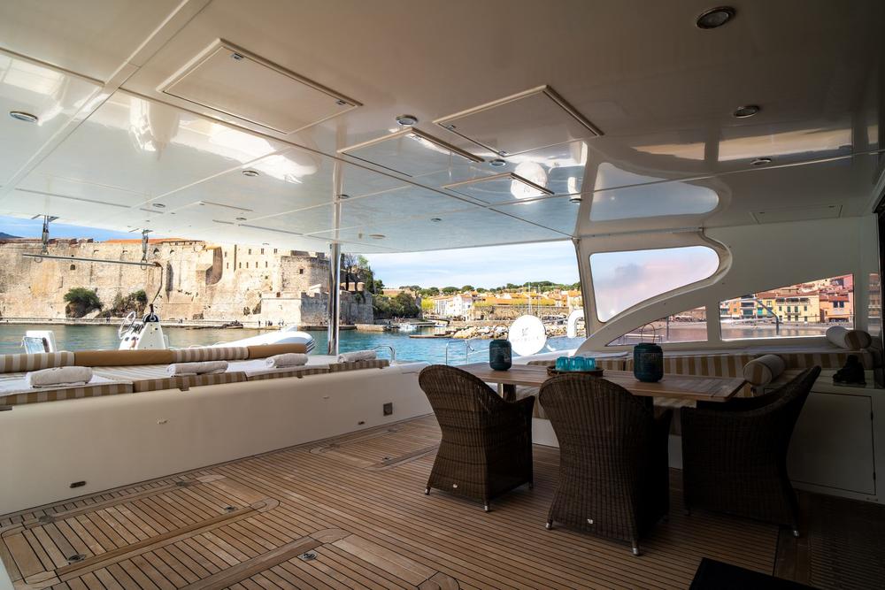 Carré d'un catamaran de luxe, table dressée face à la mer